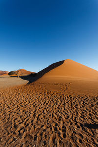 Scenic view of desert against clear blue sky