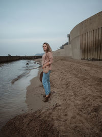 Full length of woman standing on beach against sky