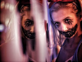 Close-up portrait of woman with face paint standing by mirror