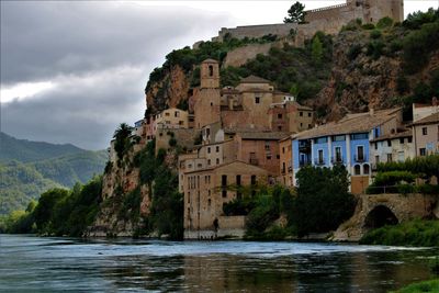 Buildings by sea against sky