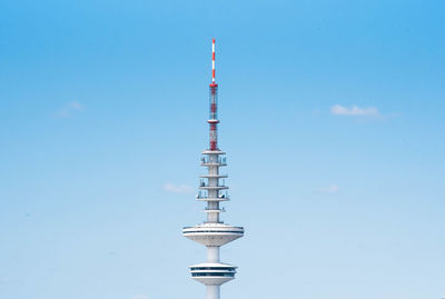 Low angle view of communications tower against blue sky