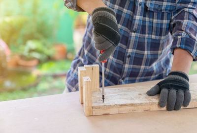 Midsection of man working on wood