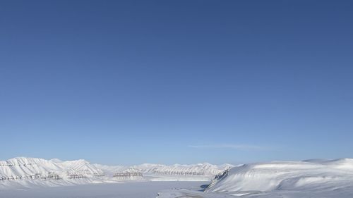 Scenic view of snowcapped mountains against clear blue sky -svalbard 