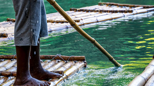 Low section of man standing in boat