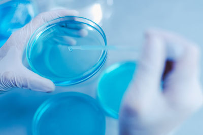 Cropped hands of scientist examining chemical in laboratory