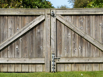 Close crop of a large wooden gate in a garden with latches