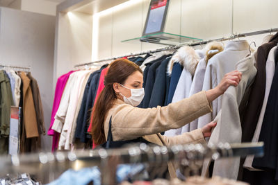 Woman wearing mask while looking at garments