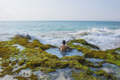 Rear view of man in sea