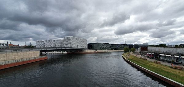 Bridge over river against cloudy sky