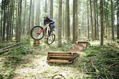 Man doing stunt with bicycle amidst trees