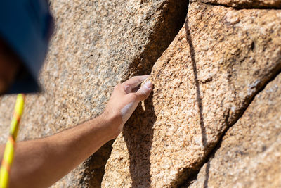 Close-up of shirtless man climbing rock