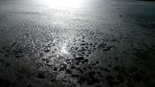 Close-up of wet sand on beach against sky