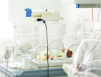 Newborn baby in hospital incubator