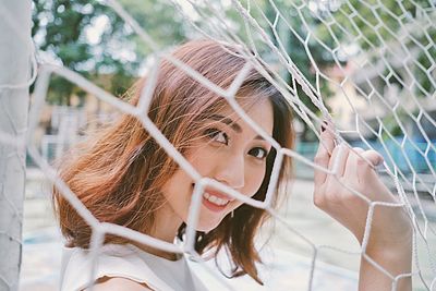 Portrait of smiling woman seen through net