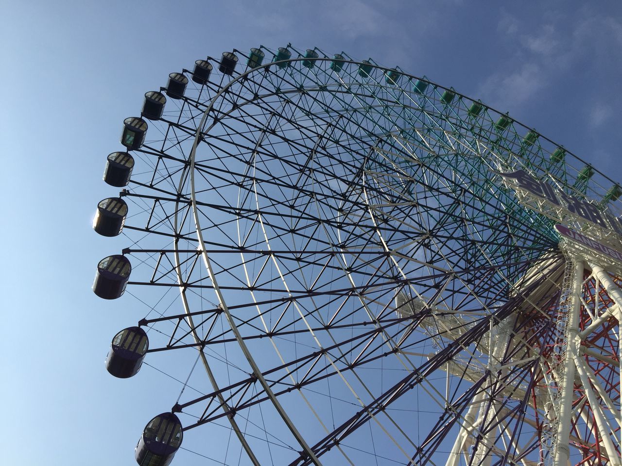 low angle view, ferris wheel, amusement park, amusement park ride, arts culture and entertainment, sky, built structure, architecture, circle, fun, enjoyment, fairground ride, leisure activity, outdoors, travel destinations, cloud - sky, decoration, large, chain swing ride, tall - high