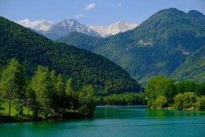 Scenic view of river by mountains against sky