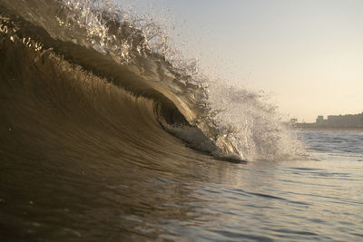 Waves splashing in sea against sky