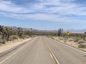 Road passing through landscape against sky