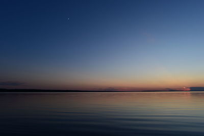 Scenic view of sea against clear sky at sunset