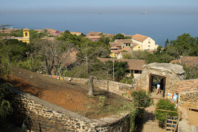 High angle view of town by sea against sky