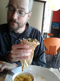 Midsection of man eating food at home