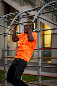 Low angle view of man exercising on railing