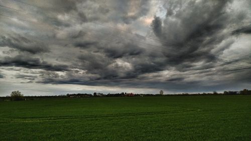 Scenic view of field against cloudy sky
