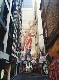 Low angle view of statue against buildings in city