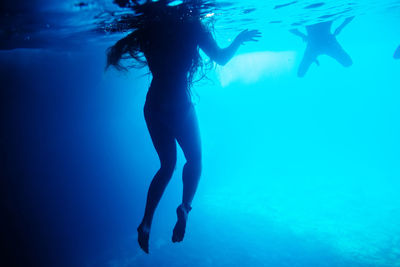 Rear view of woman swimming in sea