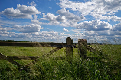 Hay bales on field against sky