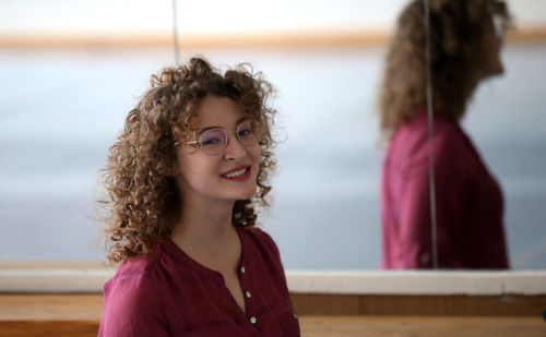 Portrait of young woman standing at beach