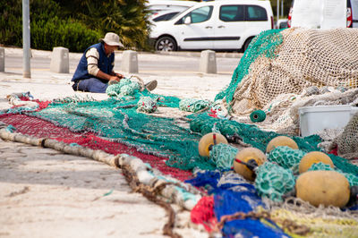 Man making fishing nets and buoys outdoors