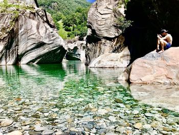 Full length of man standing on rock formation in water