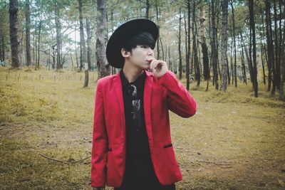 Teenage boy standing at forest