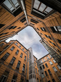 Low angle view of buildings against cloudy sky