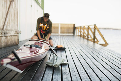 Man preparing kayak on houseboat