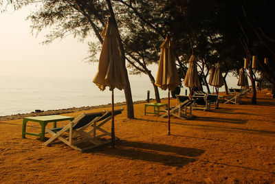 Chairs on beach against sky