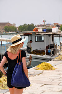 Rear view of woman walking on pier by sea