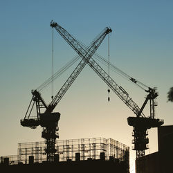 Low angle view of crane against clear sky