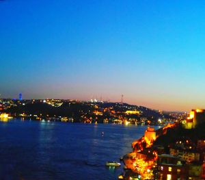 Illuminated cityscape against clear sky