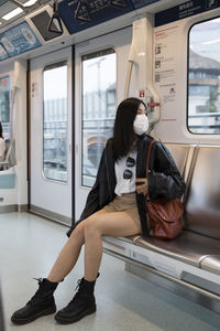 Portrait of young woman sitting in train