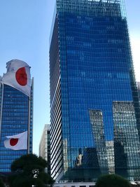 Low angle view of skyscraper against blue sky