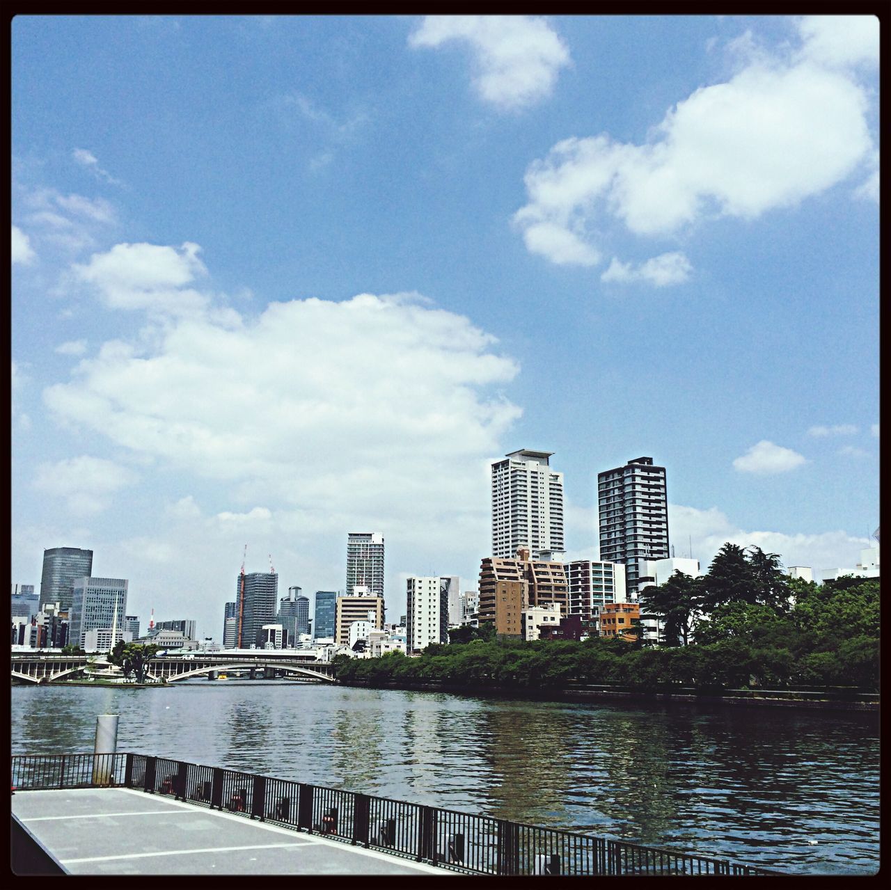 architecture, building exterior, built structure, city, sky, water, transfer print, river, cloud - sky, waterfront, skyscraper, cloud, auto post production filter, modern, cityscape, office building, railing, building, city life, reflection