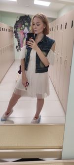 Full length of woman photographing with mobile phone