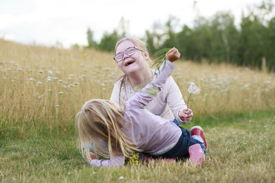 Happy sisters playing on meadow