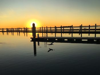 Silhouette pier on sea against sky during sunset
