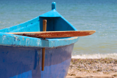 Close-up of wooden chair on shore