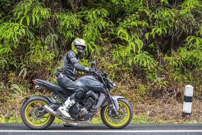 Woman stopped her motorcycle at the side of the road in thailand