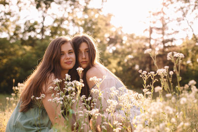 Portrait of beautiful woman standing by flowering plants