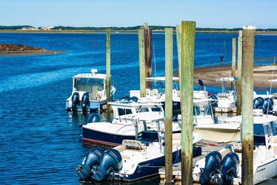 High angle view of boats moored at harbor against blue sky